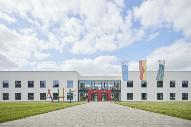 Bildungsbau Architekten. Eingangsbereich der August-Hermann-Francke-Grundschule Detmold. Putzfassade und verglaster Eingangsbereich.