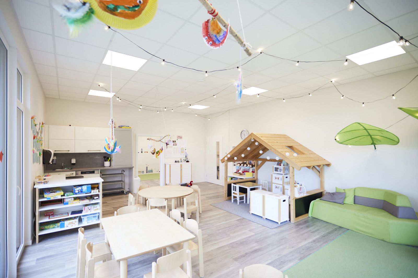 AHF Kindertagesstätte in Bad Lippspringe. Gruppenraum mit Küche. Holzhäuschen, Tische und Kinderstühle. EPU Architekten