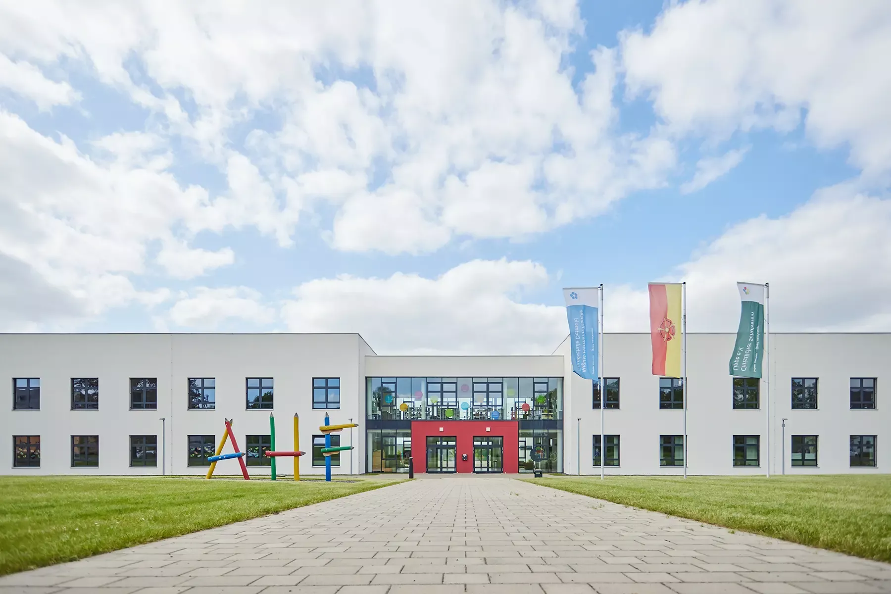 Eingangsbereich der August-Hermann-Francke-Grundschule. Putzfassade und verglaster Eingangsbereich. Ein Projekt von EPU ARCHITEKTEN.
